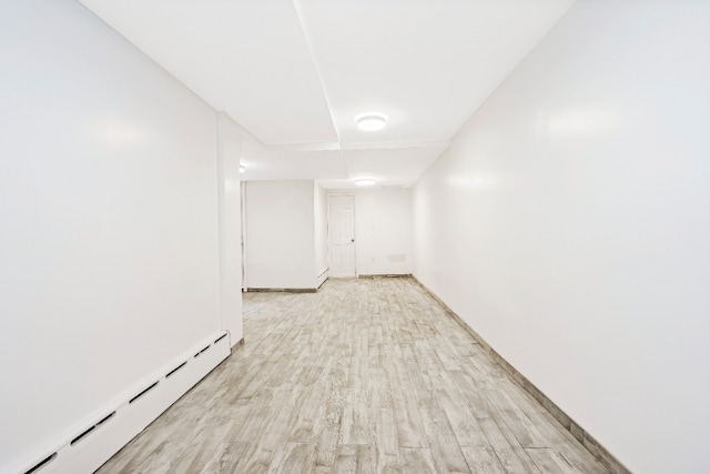 309 Covert St, New York City, NY 11237 - spare room featuring a baseboard heating unit and light wood-type flooring