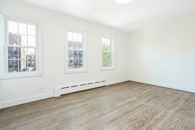 309 Covert St, New York City, NY 11237 - spare room with a baseboard heating unit, wood finished floors, and baseboards