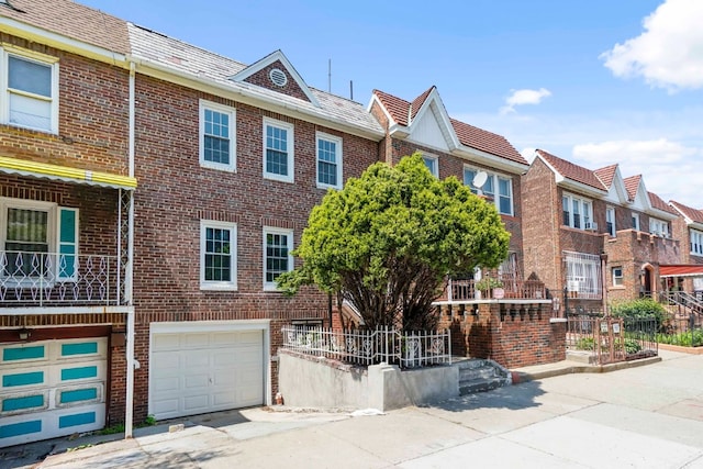 309 Covert St, New York City, NY 11237 - view of property featuring brick siding, an attached garage, a residential view, and driveway