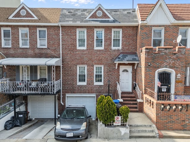 309 Covert St, New York City, NY 11237 - townhome / multi-family property featuring brick siding, an attached garage, and driveway