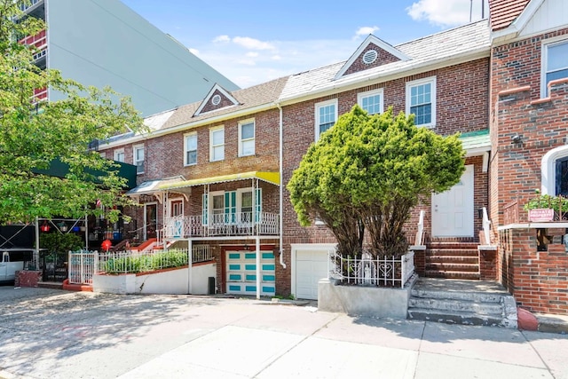 309 Covert St, New York City, NY 11237 - townhome / multi-family property featuring entry steps, a garage, brick siding, and driveway