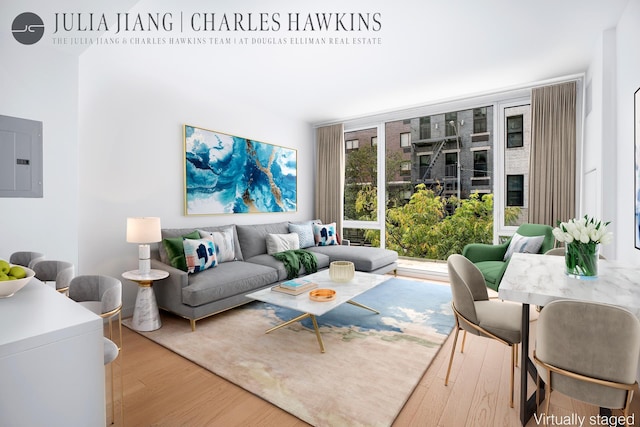living area featuring electric panel, a wall of windows, and wood finished floors