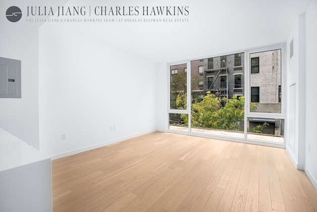 540 W 49th St Unit 307S, New York City, NY 10019 - unfurnished room featuring electric panel, light wood finished floors, floor to ceiling windows, and washer / dryer