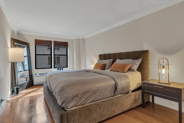 bedroom featuring crown molding and wood finished floors