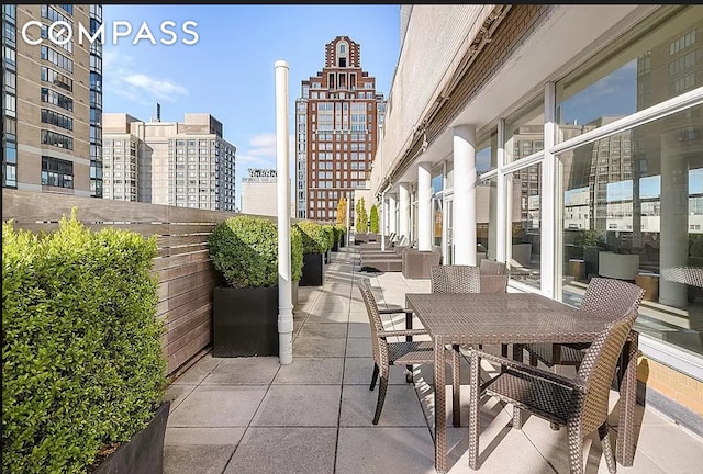 view of patio with outdoor dining area and a view of city