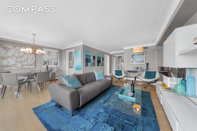 living area featuring an inviting chandelier, crown molding, and light wood-type flooring