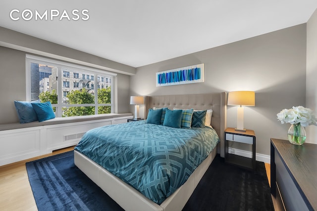 bedroom featuring wood finished floors, visible vents, and baseboards