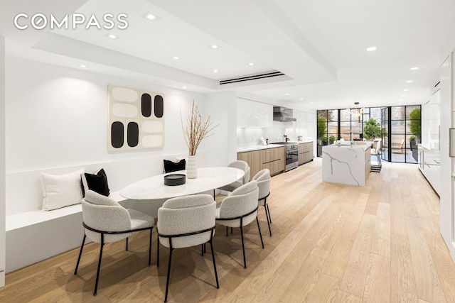 54 E 80th St, New York City, NY 10075 - dining room with light wood finished floors, recessed lighting, a raised ceiling, and a wall of windows