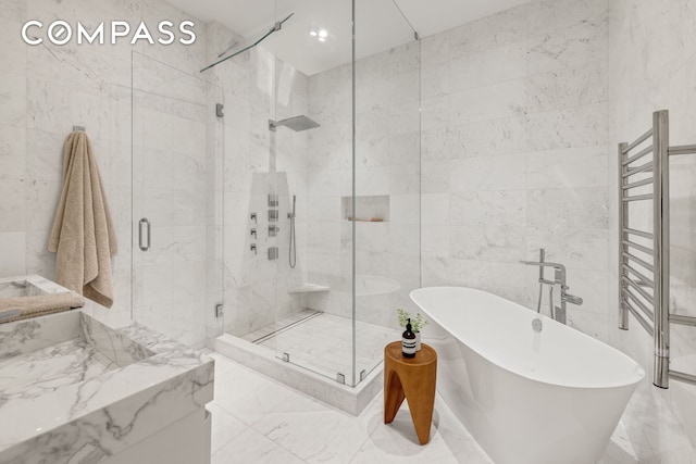 54 E 80th St, New York City, NY 10075 - full bathroom featuring marble tiled flooring, a freestanding tub, tile walls, a towel warmer, and a stall shower