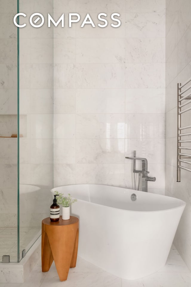 54 E 80th St, New York City, NY 10075 - full bath featuring a towel warmer, a freestanding tub, tile walls, radiator heating unit, and marble finish floors