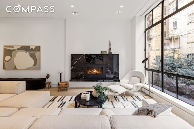 54 E 80th St, New York City, NY 10075 - living room with healthy amount of natural light, a high end fireplace, wood finished floors, and recessed lighting