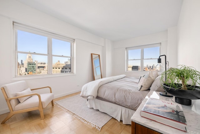 bedroom featuring a view of city and baseboards