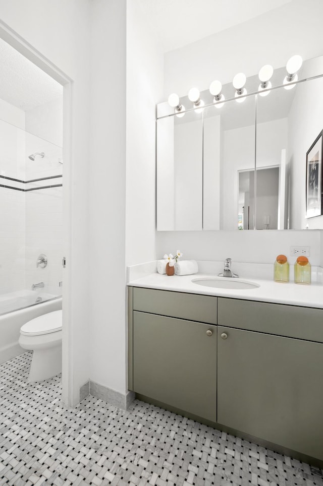 full bathroom with vanity, toilet,  shower combination, and baseboards