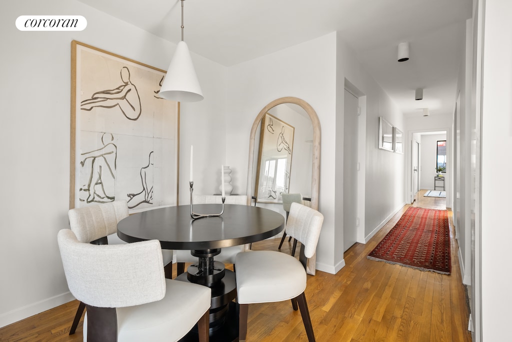 dining room featuring baseboards, wood finished floors, and visible vents
