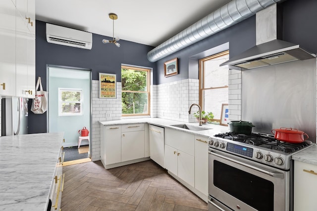 kitchen featuring a sink, dishwasher, an AC wall unit, gas stove, and wall chimney exhaust hood