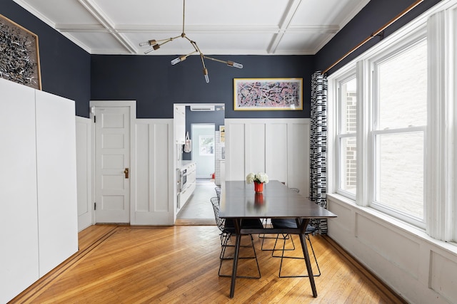 dining area with an inviting chandelier, light wood-type flooring, plenty of natural light, and coffered ceiling