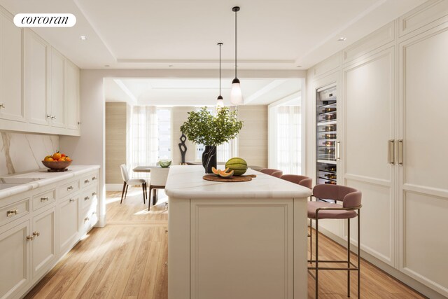 16 5th Ave Unit 6, New York City, NY 10011 - kitchen featuring light countertops, light wood finished floors, a breakfast bar, a center island, and visible vents