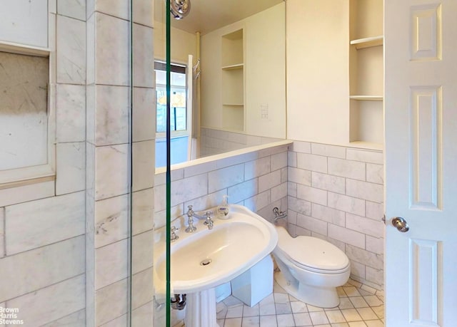 2244 Bronx Park E Unit 1B, New York City, NY 10467 - half bathroom with tile walls, built in features, toilet, a sink, and tile patterned floors