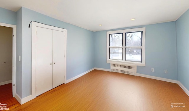 2244 Bronx Park E Unit 1B, New York City, NY 10467 - unfurnished bedroom with radiator, light wood-style flooring, a closet, baseboards, and recessed lighting