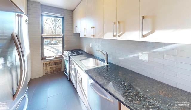 2244 Bronx Park E Unit 1B, New York City, NY 10467 - kitchen featuring appliances with stainless steel finishes, a sink, backsplash, white cabinetry, and dark stone countertops