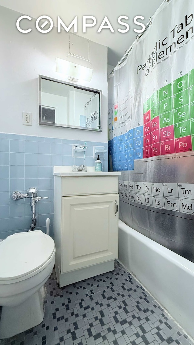 full bath featuring toilet, tile patterned floors, tile walls, and vanity