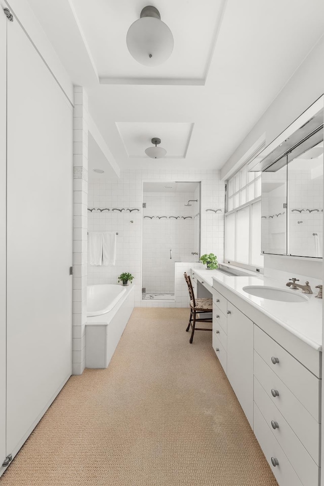 full bathroom featuring a shower stall, a bath, and vanity