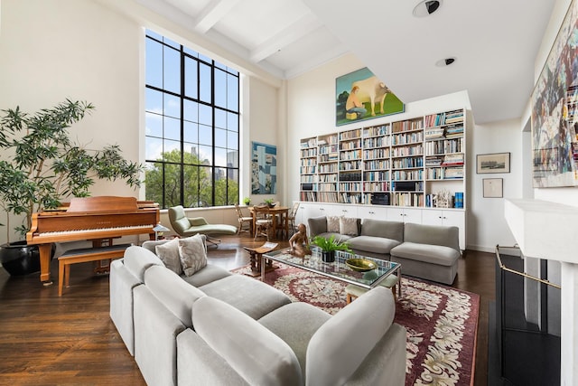 sitting room featuring beamed ceiling, baseboards, and wood finished floors