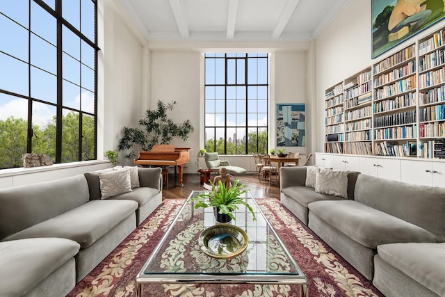 living area with wood finished floors and beam ceiling