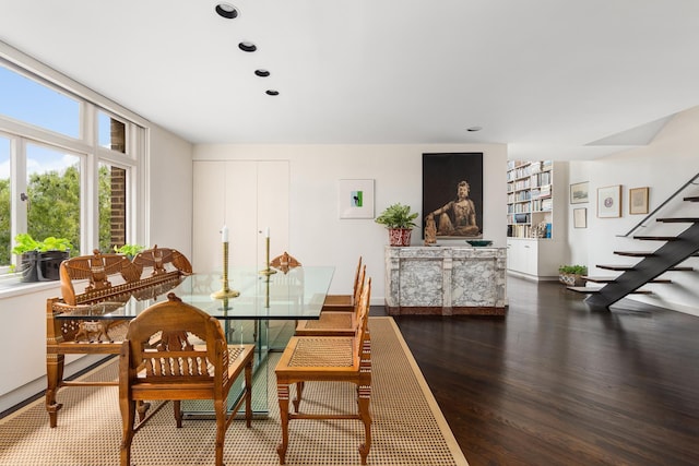 dining room featuring wood finished floors, a wealth of natural light, recessed lighting, and stairway