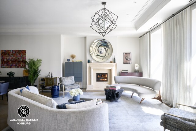 101 W 78th St Unit 5B, New York City, NY 10024 - living room featuring healthy amount of natural light, a lit fireplace, crown molding, and a raised ceiling