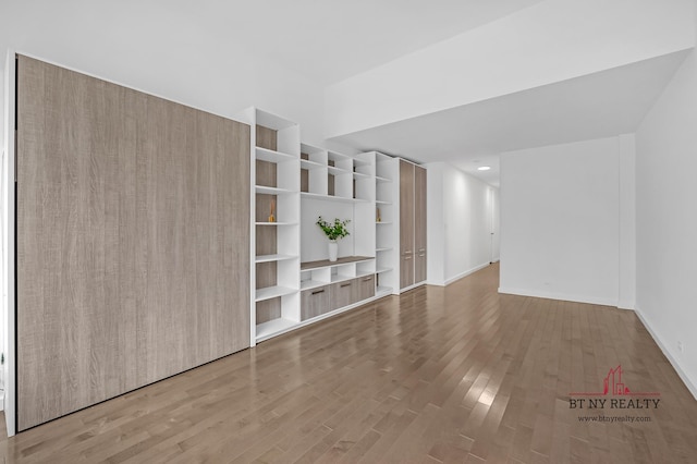 350 W 50th St Unit 6-R, New York City, NY 10019 - unfurnished living room with wood finished floors and baseboards