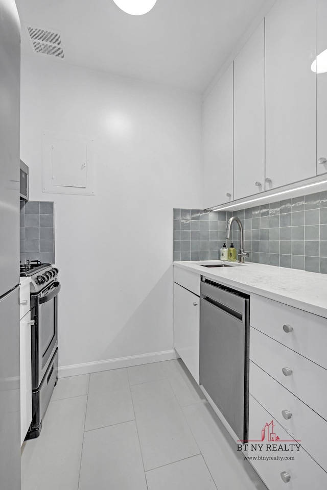 350 W 50th St Unit 6-R, New York City, NY 10019 - kitchen with stainless steel appliances, a sink, tasteful backsplash, and white cabinets
