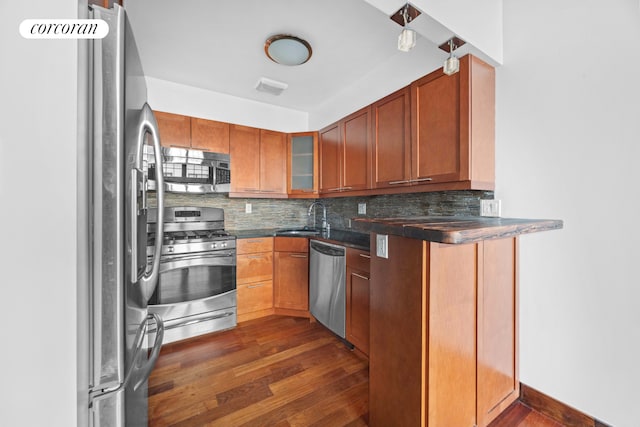 605 Manhattan Ave Unit 4, New York City, NY 11222 - kitchen featuring appliances with stainless steel finishes, dark wood-type flooring, tasteful backsplash, dark countertops, and glass insert cabinets