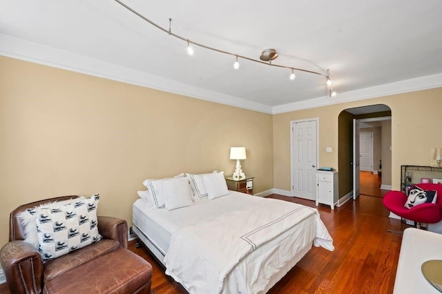 9437 Shore Rd Unit A1, New York City, NY 11209 - bedroom featuring arched walkways, dark wood-type flooring, baseboards, and track lighting