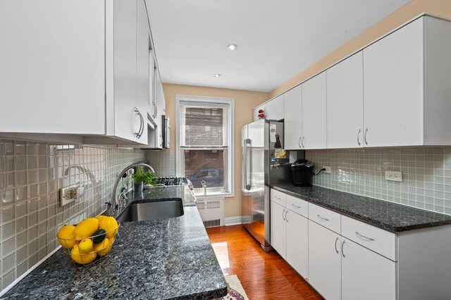 9437 Shore Rd Unit A1, New York City, NY 11209 - kitchen with freestanding refrigerator, a sink, radiator heating unit, wood finished floors, and backsplash