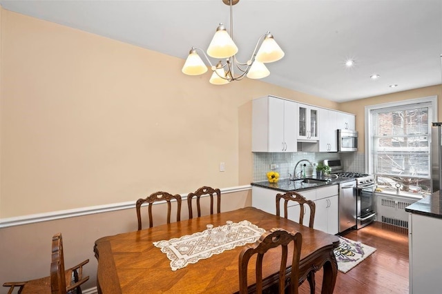 9437 Shore Rd Unit A1, New York City, NY 11209 - dining space featuring a chandelier, radiator heating unit, dark wood-style floors, and recessed lighting