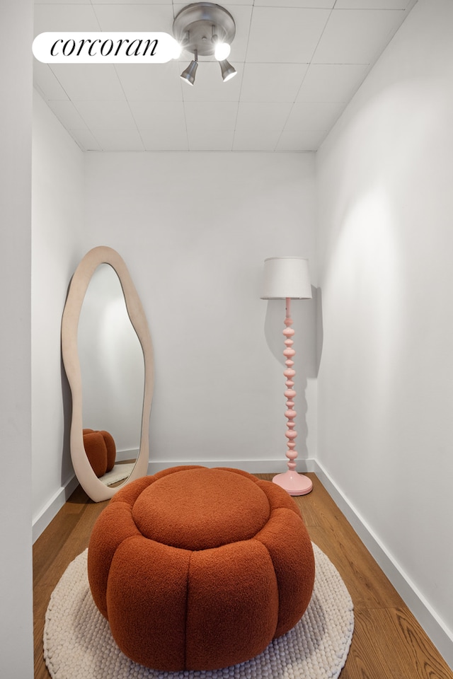 sitting room with baseboards and wood finished floors