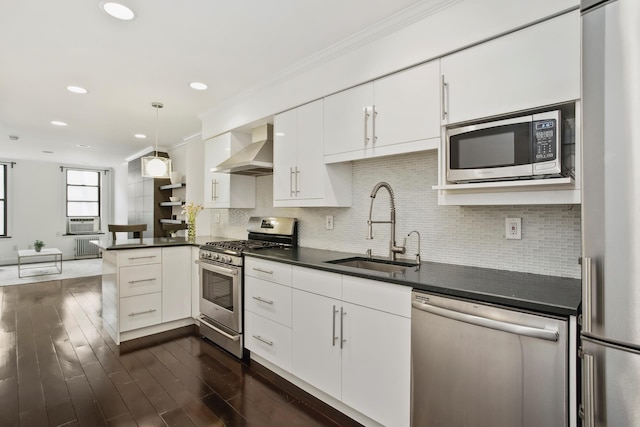 334 E 5th St Unit 3E, New York City, NY 10003 - kitchen featuring appliances with stainless steel finishes, wall chimney exhaust hood, a sink, dark countertops, and recessed lighting