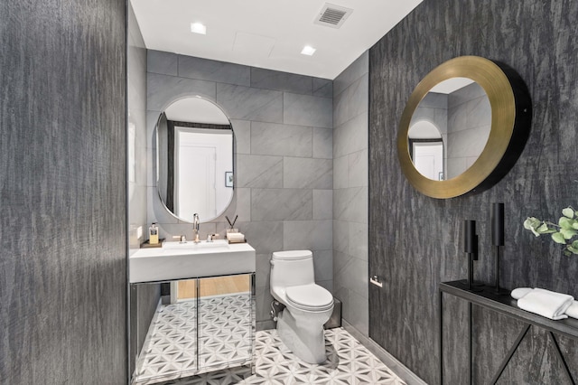 269 W 87th St Phb, Phb, New York City, NY 10024 - bathroom with tile patterned flooring, visible vents, toilet, a sink, and tile walls