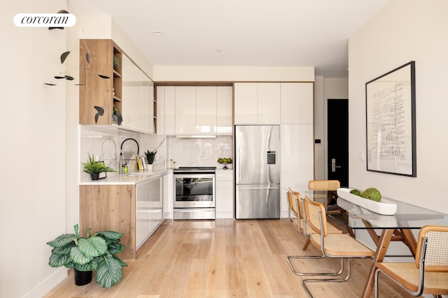 1122 Lafayette Ave Unit 3A, New York City, NY 11221 - kitchen featuring appliances with stainless steel finishes, light wood-style floors, light countertops, and open shelves