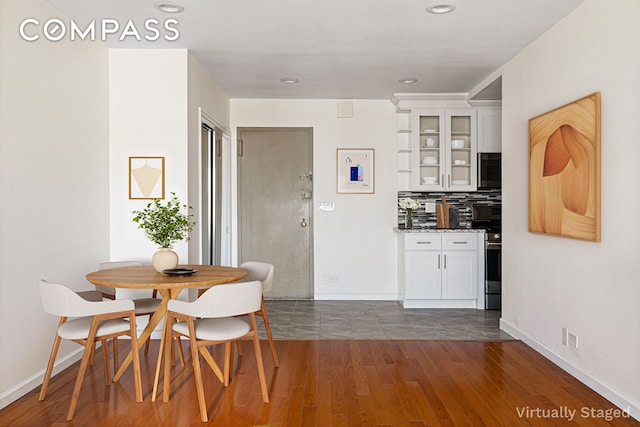 interior space with baseboards, recessed lighting, and dark wood-style flooring