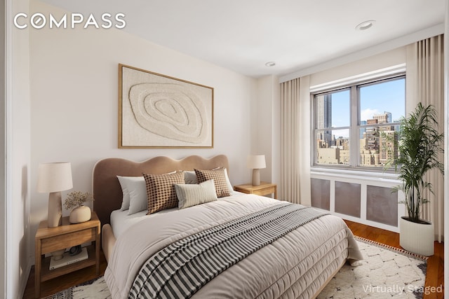 bedroom featuring wood finished floors, recessed lighting, and baseboards