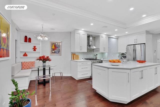 kitchen featuring appliances with stainless steel finishes, wall chimney range hood, light countertops, recessed lighting, and dark wood-style floors