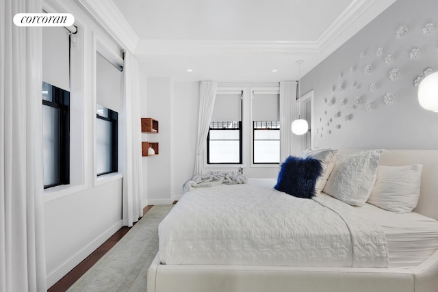 bedroom with ornamental molding, wood finished floors, and baseboards