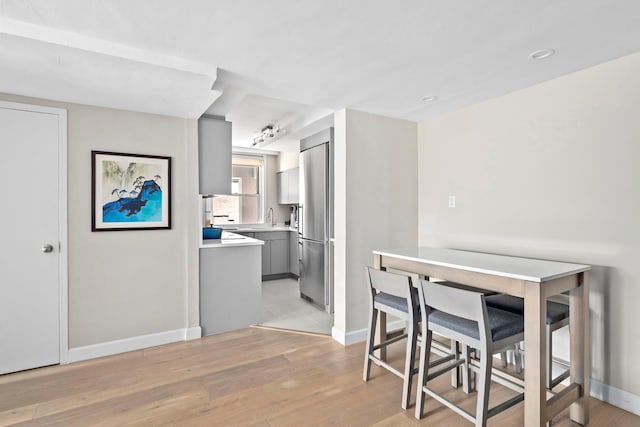dining area with light wood-style floors and baseboards