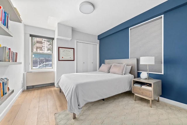 bedroom with baseboards, a closet, and hardwood / wood-style floors