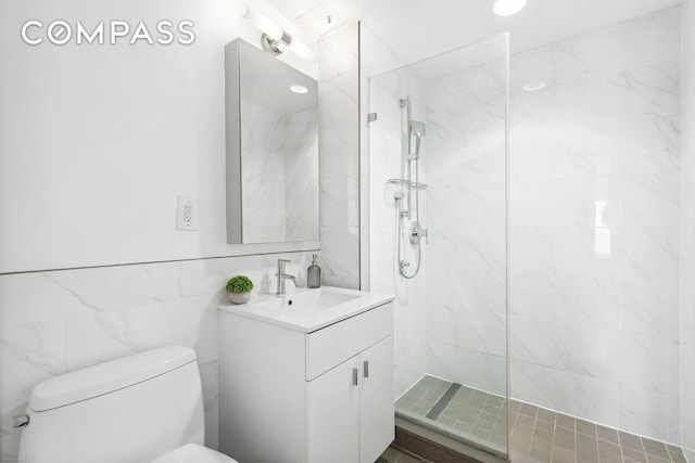 full bath with a walk in shower, toilet, vanity, and tile walls