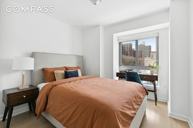 bedroom featuring light wood-style floors and baseboards