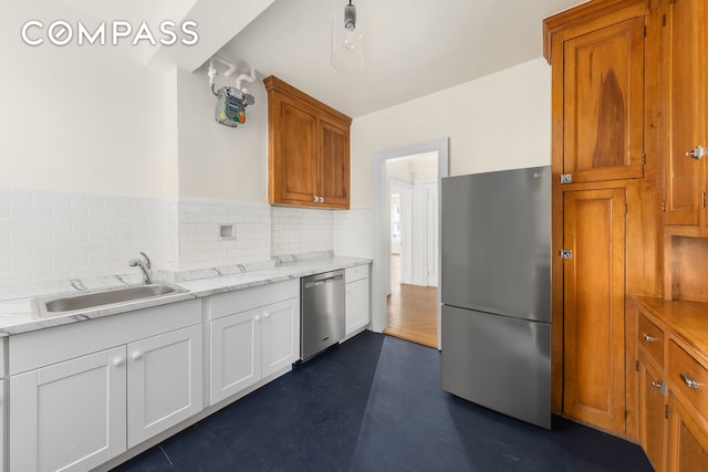 kitchen featuring a sink, white cabinets, brown cabinetry, and stainless steel appliances