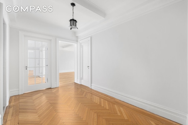 spare room featuring baseboards and beamed ceiling